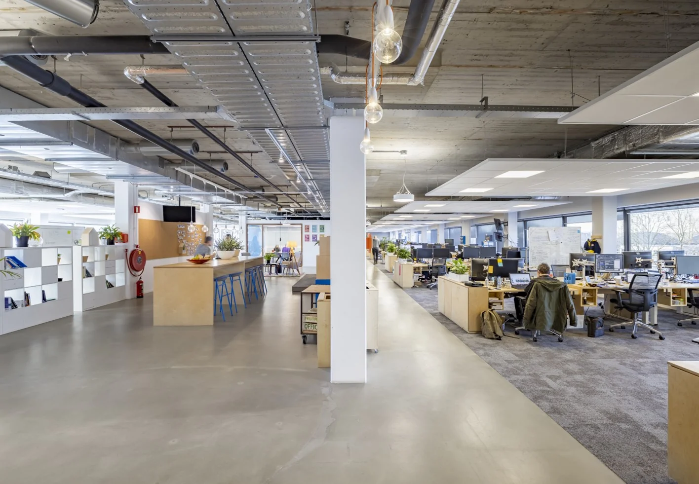 Moderne en ruime kantoortuin aan de Joan Muyskenweg met open werkplekken en een informele ontmoetingsruimte.