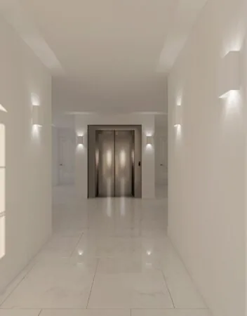 Licht marmeren hal met moderne wandverlichting en een dubbele lift bij Koningslaan.