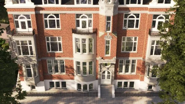 Voorgevel van een statig, rood bakstenen herenhuis aan de Koningslaan met witte kozijnen, erkers en sierlijke architectonische details.