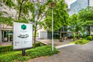 Informatiebord van South Point Offices in een groene, modern aangeklede kantoortuin.