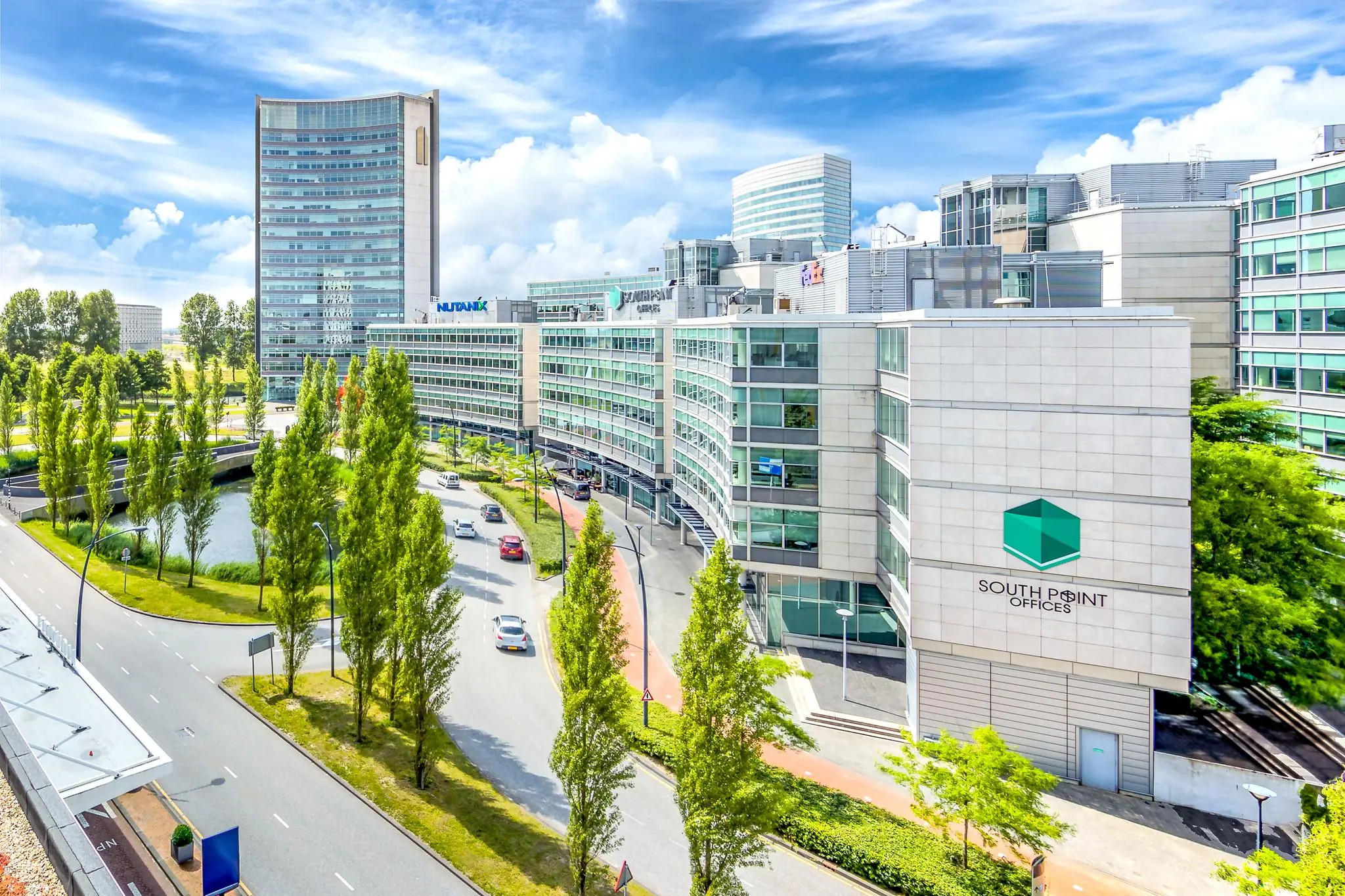 Modern kantoorgebouw South Point Offices met omliggende bedrijfsgebouwen en groenstroken in een zakendistrict.