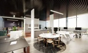 Modern en licht open kantoor met werkplekken, zithoek, ronde vergadertafel en geïntegreerde keuken.