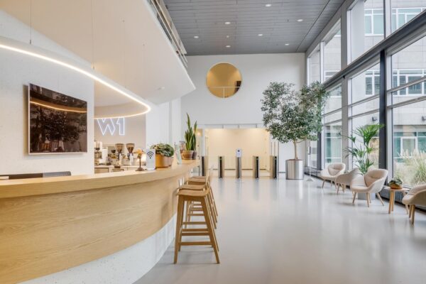 Moderne en lichte ontvangsthal aan de Winthontlaan met een koffiebar, zithoek en toegangspoortjes.