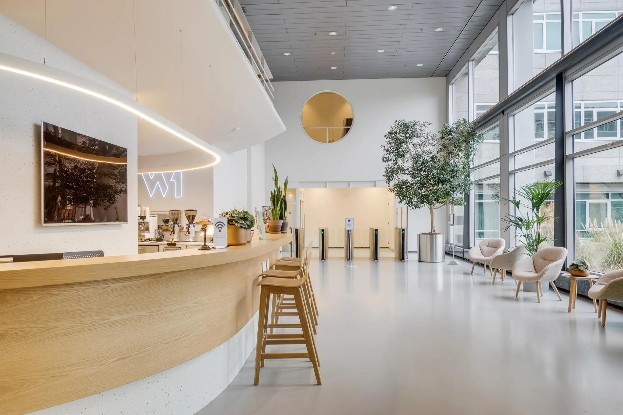 Moderne en lichte ontvangsthal aan de Winthontlaan met een koffiebar, zithoek en toegangspoortjes.