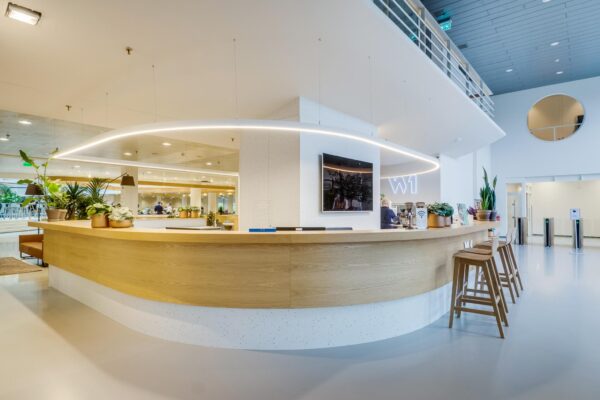 Moderne receptiebalie met houten afwerking en planten in de entree van het Winthontlaan-kantoorgebouw.