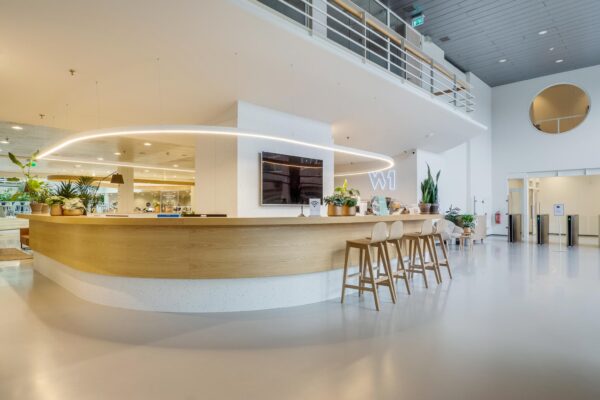 Moderne receptie met houten balie en planten in de entree van kantoorgebouw Winthontlaan W1.