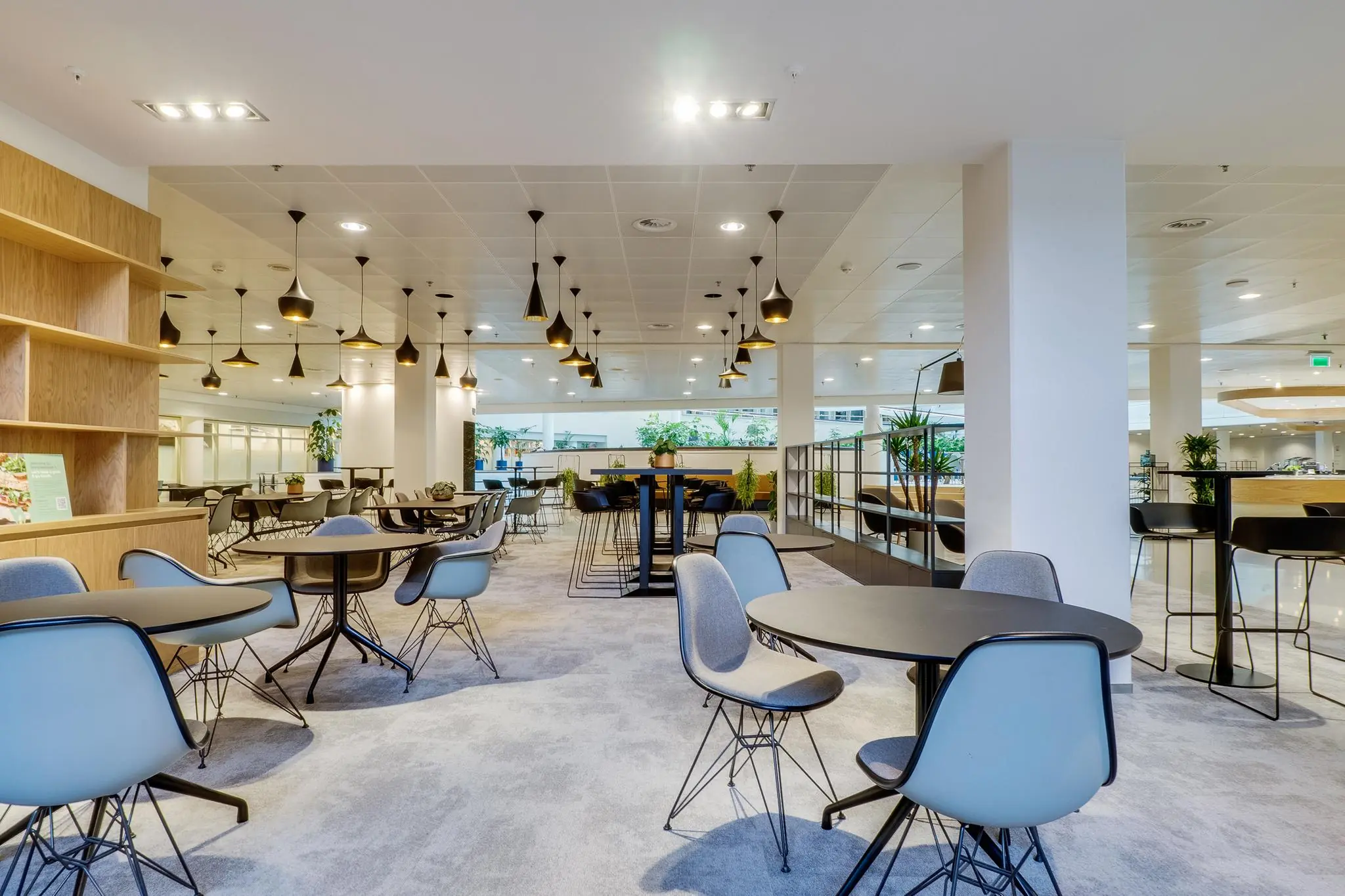 Moderne en ruim opgezette bedrijfsrestauratie aan de Winthontlaan met ronde tafels, designstoelen en sfeerverlichting.