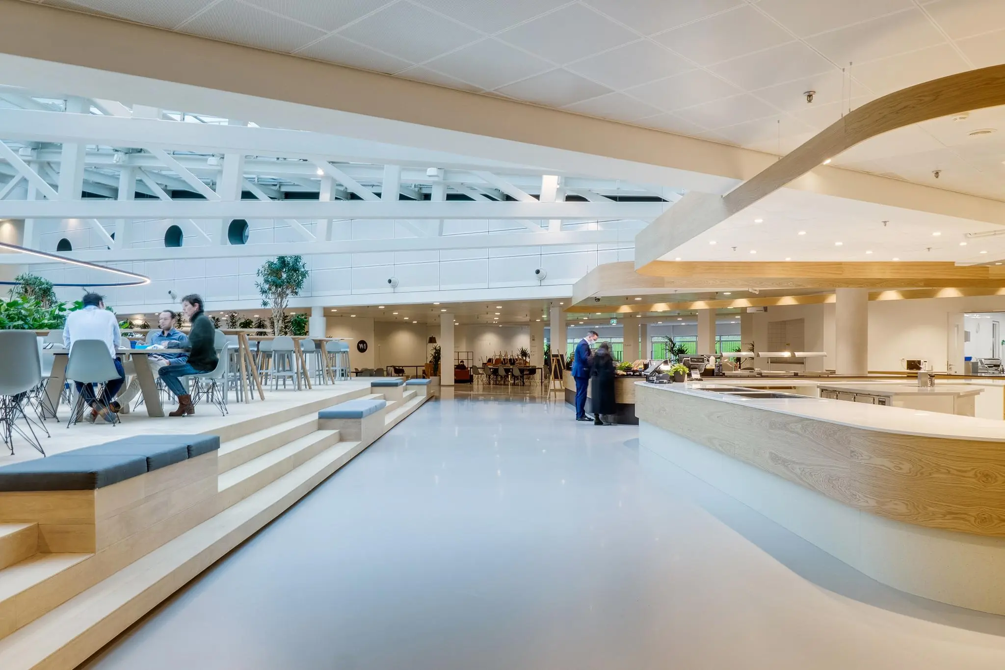 Moderne en open bedrijfsrestaurant aan de Winthontlaan met zitgedeelte, planten en een ruime counter.