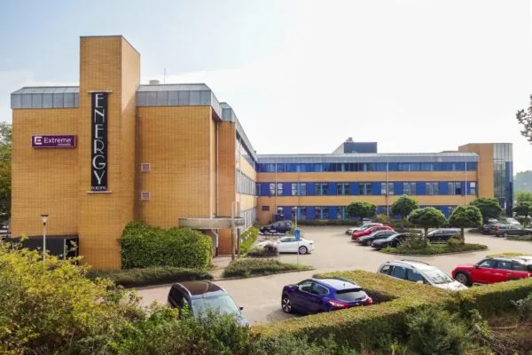 Kantoorgebouw "Energy Building" aan de Kernkade met parkeerterrein en geparkeerde auto's op de voorgrond.
