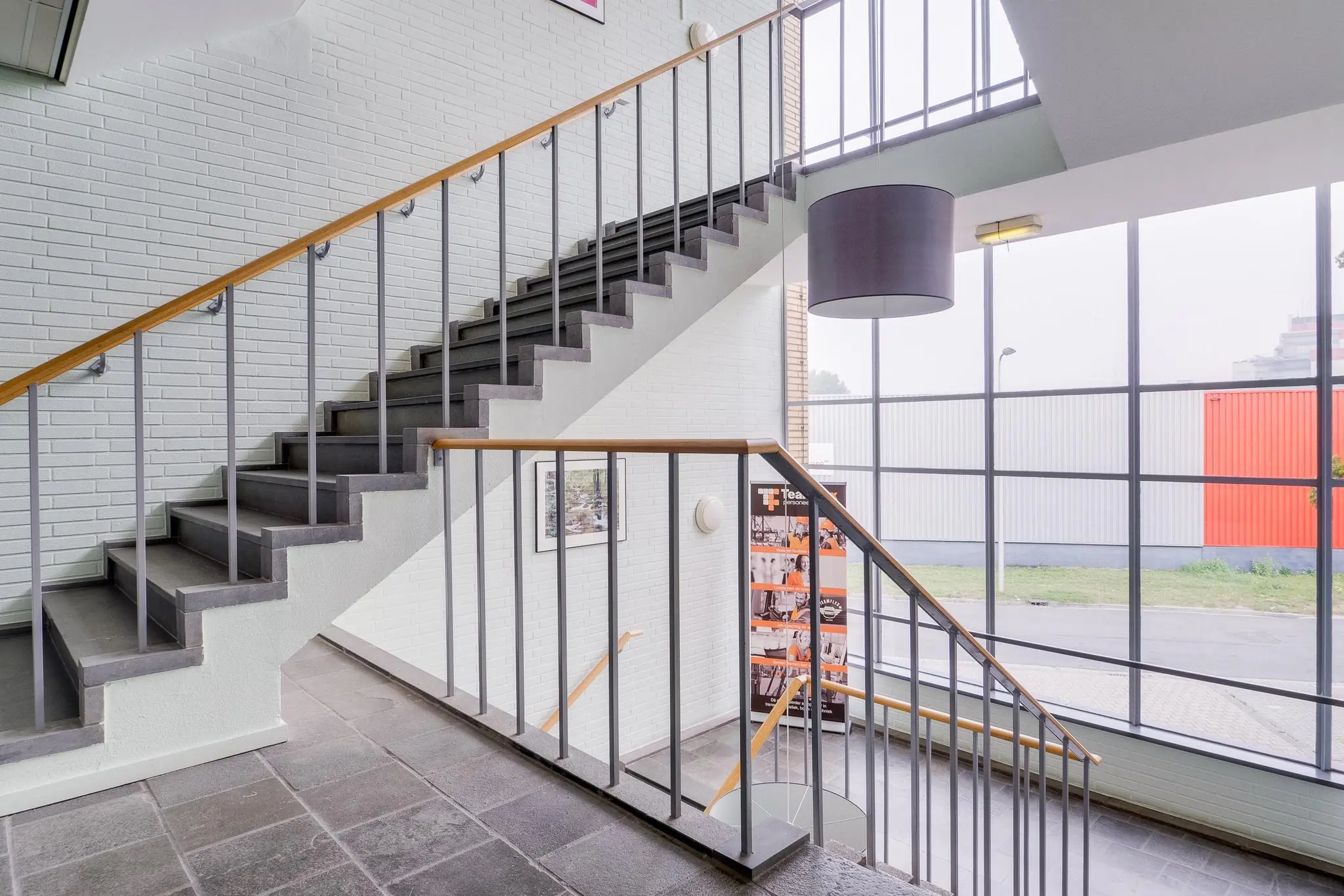 Trappenhuis met modern ontwerp en grote ramen in een bedrijfsgebouw aan de Kernkade.
