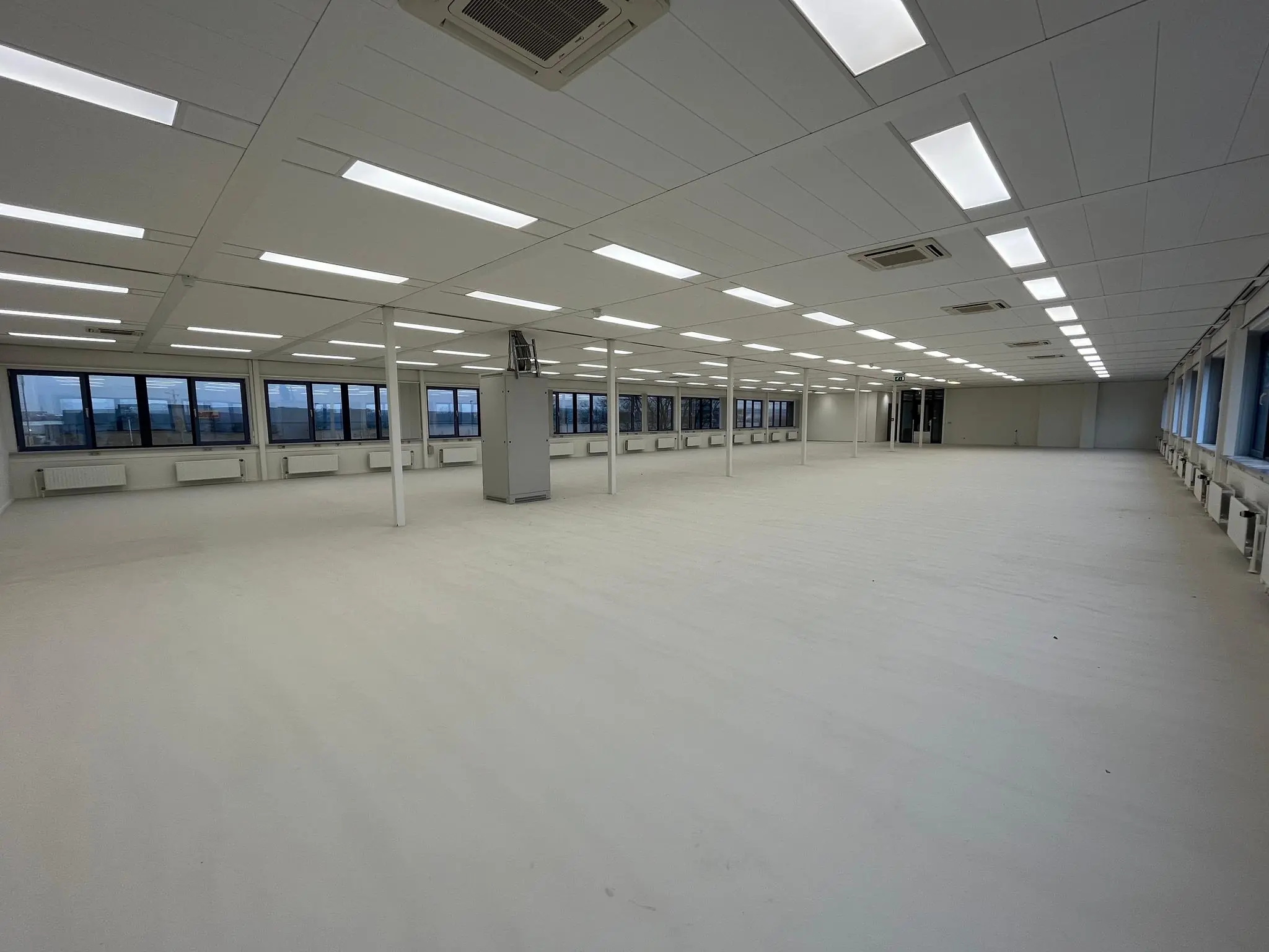 Lege, ruimtelijke kantoorverdieping aan de Kernkade met witte vloer, systeemplafond en grote ramen rondom.