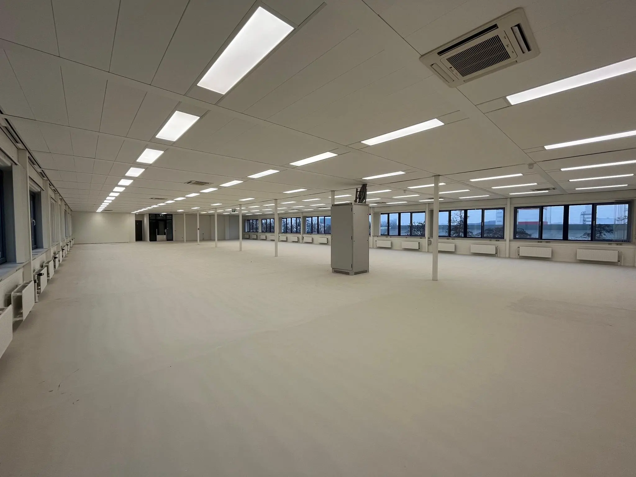 Ruime, lege kantoorverdieping aan de Kernkade met systeemplafond, tl-verlichting en grote ramen.