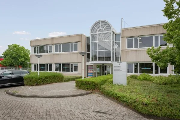 Vooraanzicht van een kantoorgebouw aan de Energieweg 3 met het logo van Veltman Uitgevers op de ramen.