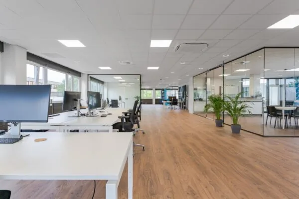 Modern en licht kantoorpand aan de Energieweg met open werkplekken, glazen vergaderruimtes en houten vloer.