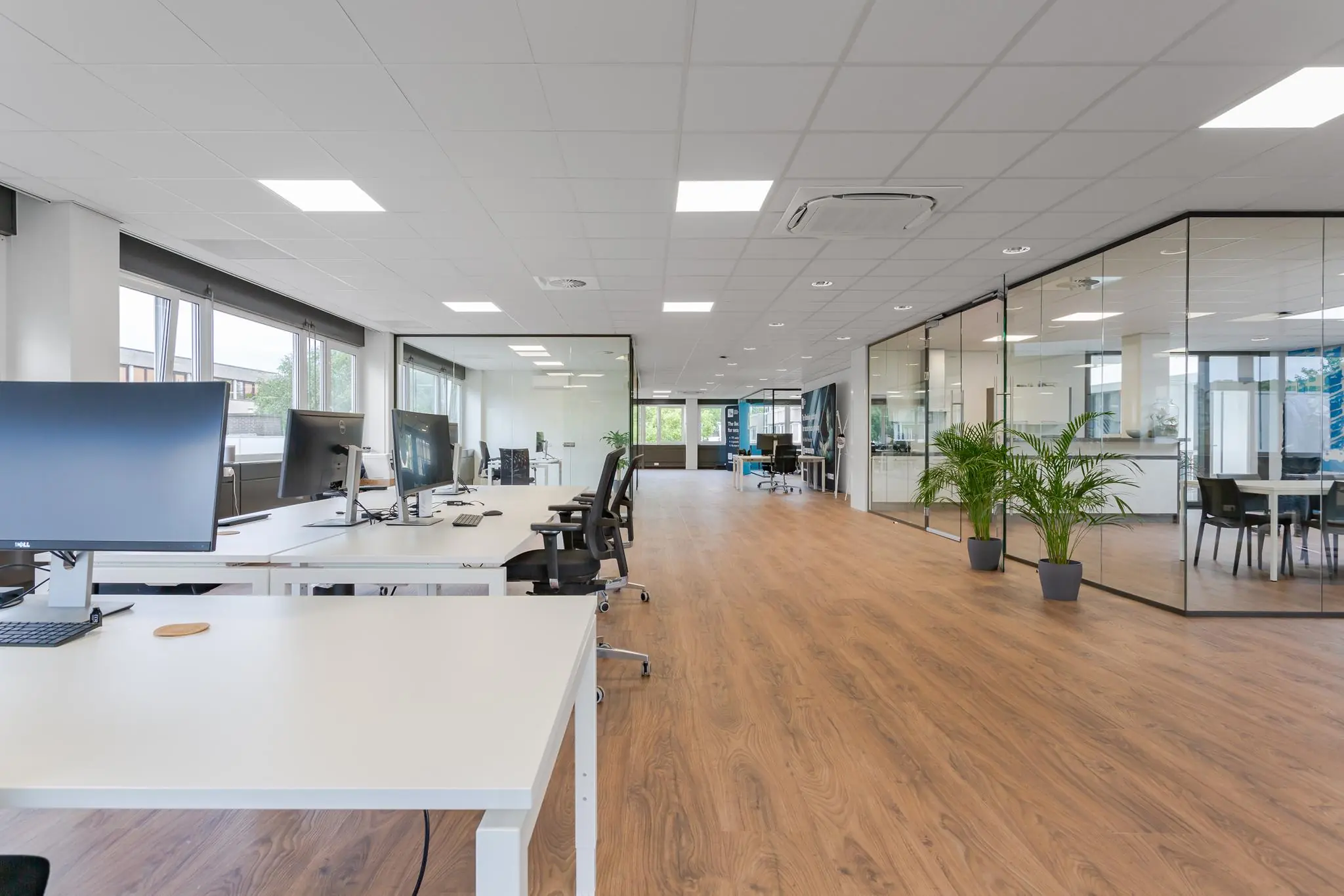 Modern en licht kantoorpand aan de Energieweg met open werkplekken, glazen vergaderruimtes en houten vloer.