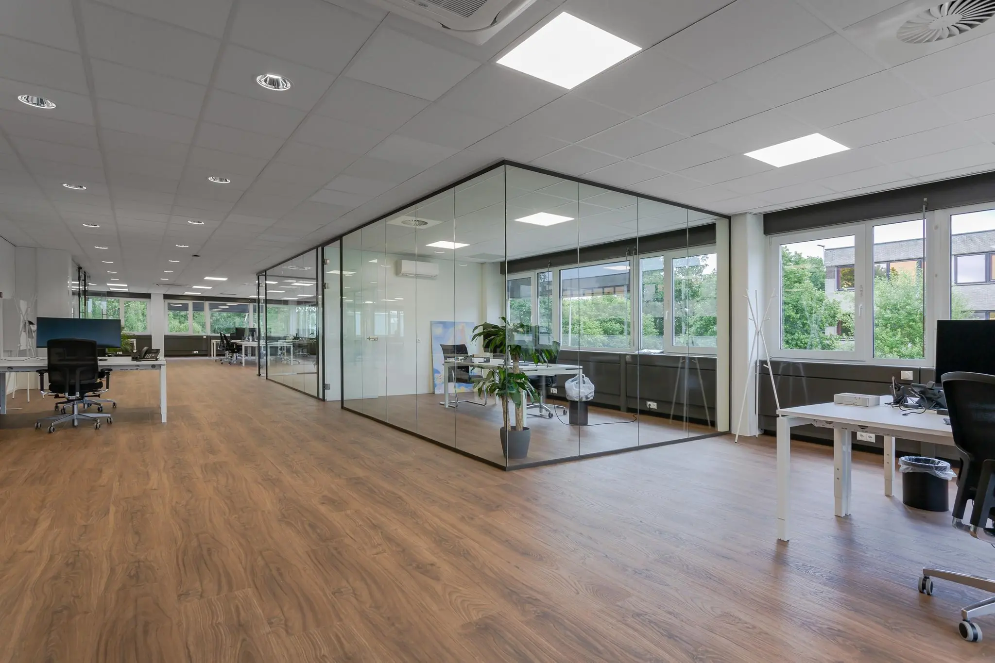 Licht en modern kantoorpand aan de Energieweg met glazen vergaderruimte en houten vloer.