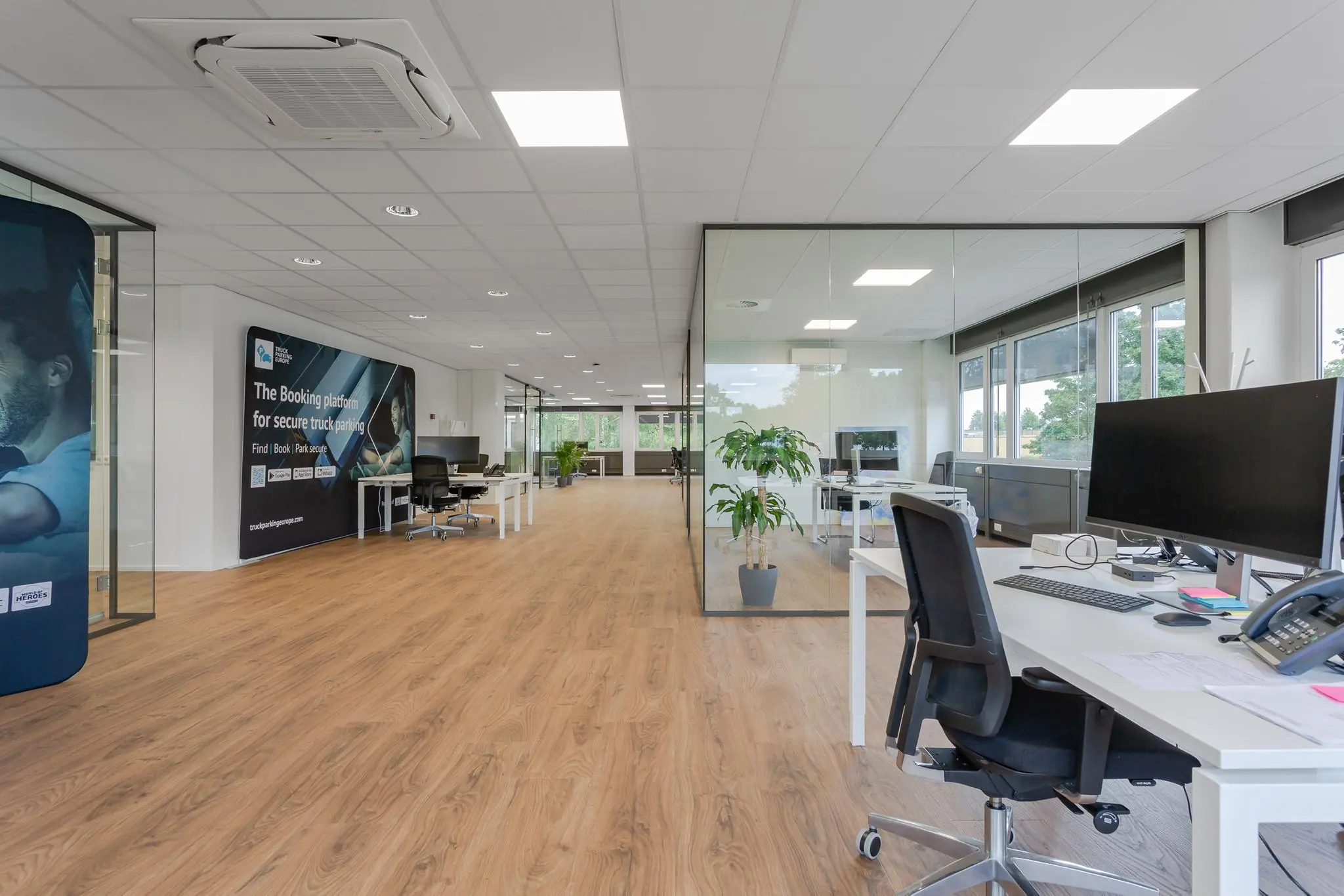 Modern kantoorinterieur aan de Energieweg met glazen vergaderruimtes, werkplekken en grote ramen.