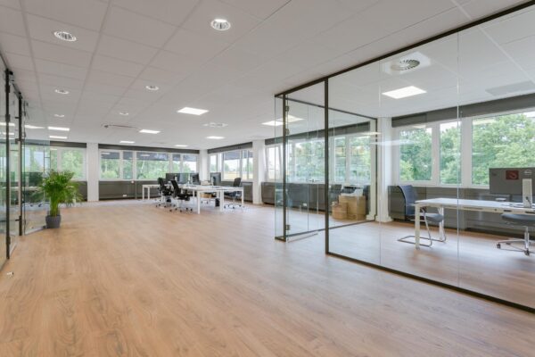 Modern en licht kantoorinterieur aan de Energieweg met glazen vergaderruimtes en werkplekken.