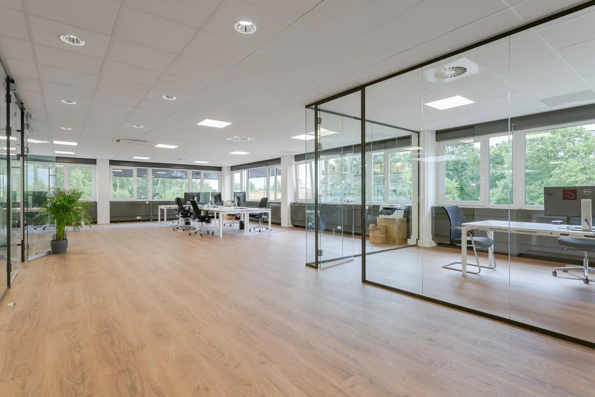 Modern en licht kantoorinterieur aan de Energieweg met glazen vergaderruimtes en werkplekken.