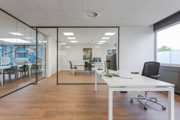 Modern kantoorinterieur met glazen wanden, houten vloer en meerdere werkplekken bij Energieweg.