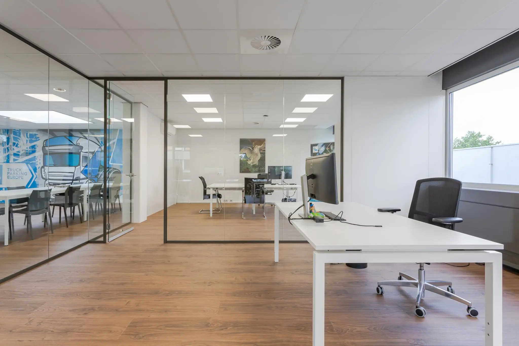 Modern kantoorinterieur met glazen wanden, houten vloer en meerdere werkplekken bij Energieweg.