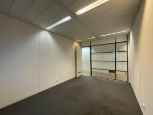 Lege kantoorruimte aan de Zekeringstraat met glazen tussenwand en systeemplafond.