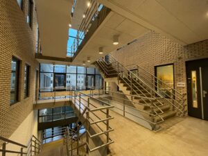 Modern trappenhuis met metalen leuningen en grote ramen in een gebouw aan de Zekeringstraat.