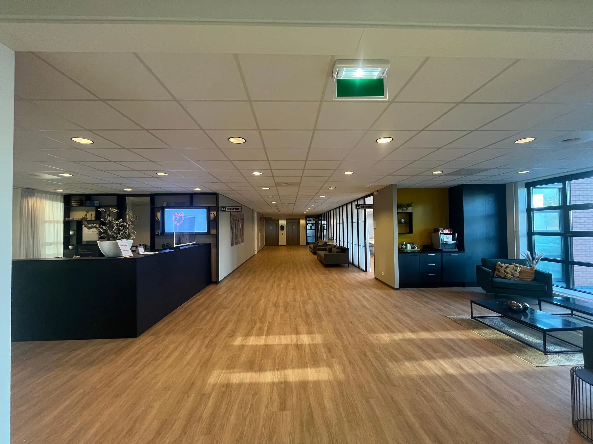 Moderne en ruime ontvangstruimte van Zonnebaan met receptiebalie, zitgedeelte en koffiecorner.