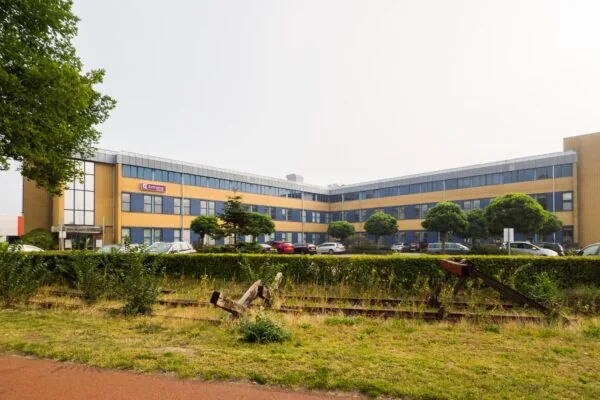 Kantoorgebouw aan de Kernkade met het logo van het bedrijf Externet op de gevel en een beëindigd stuk spoor op de voorgrond.