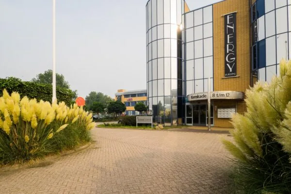 Zakelijk kantoorgebouw met spiegelende ramen aan de Kernkade, met de naam 'Energy Building' op de gevel.