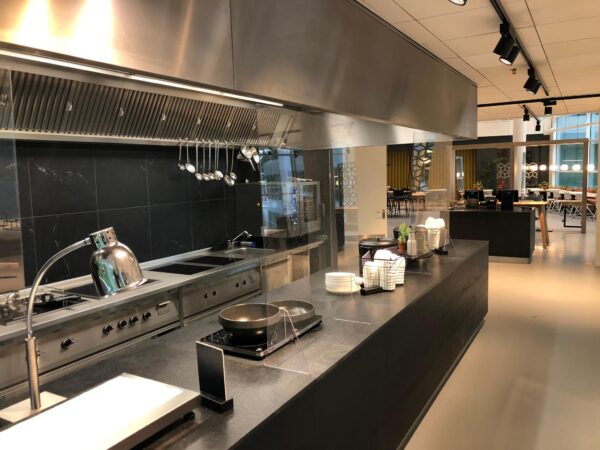 Moderne bedrijfskeuken met serveer- en kookstations in een kantine op Newtonlaan.