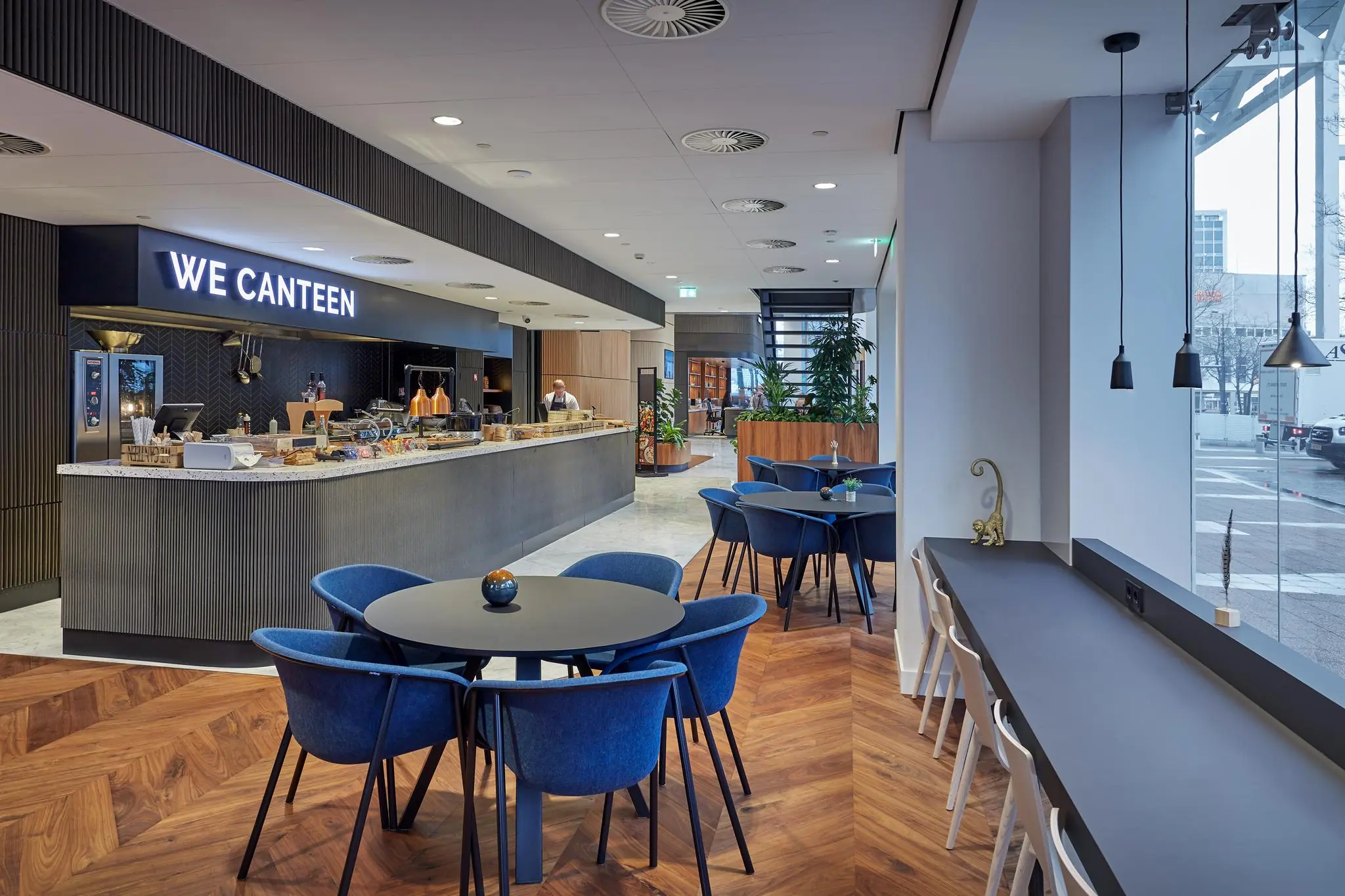 Moderne bedrijfsrestaurant genaamd "We Canteen" met zitplaatsen en uitzicht op straat in gebouw Blaak.