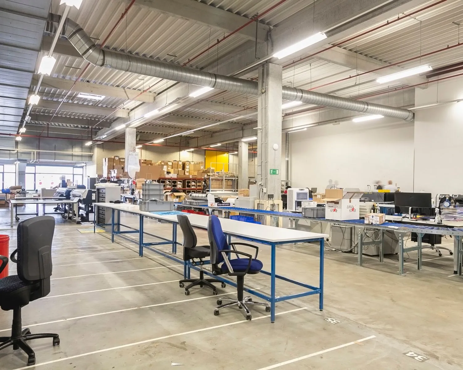 Ruime, industriële kantoorruimte aan de Bolderweg 2 in Almere met werkplekken, computers en opslagstellingen.