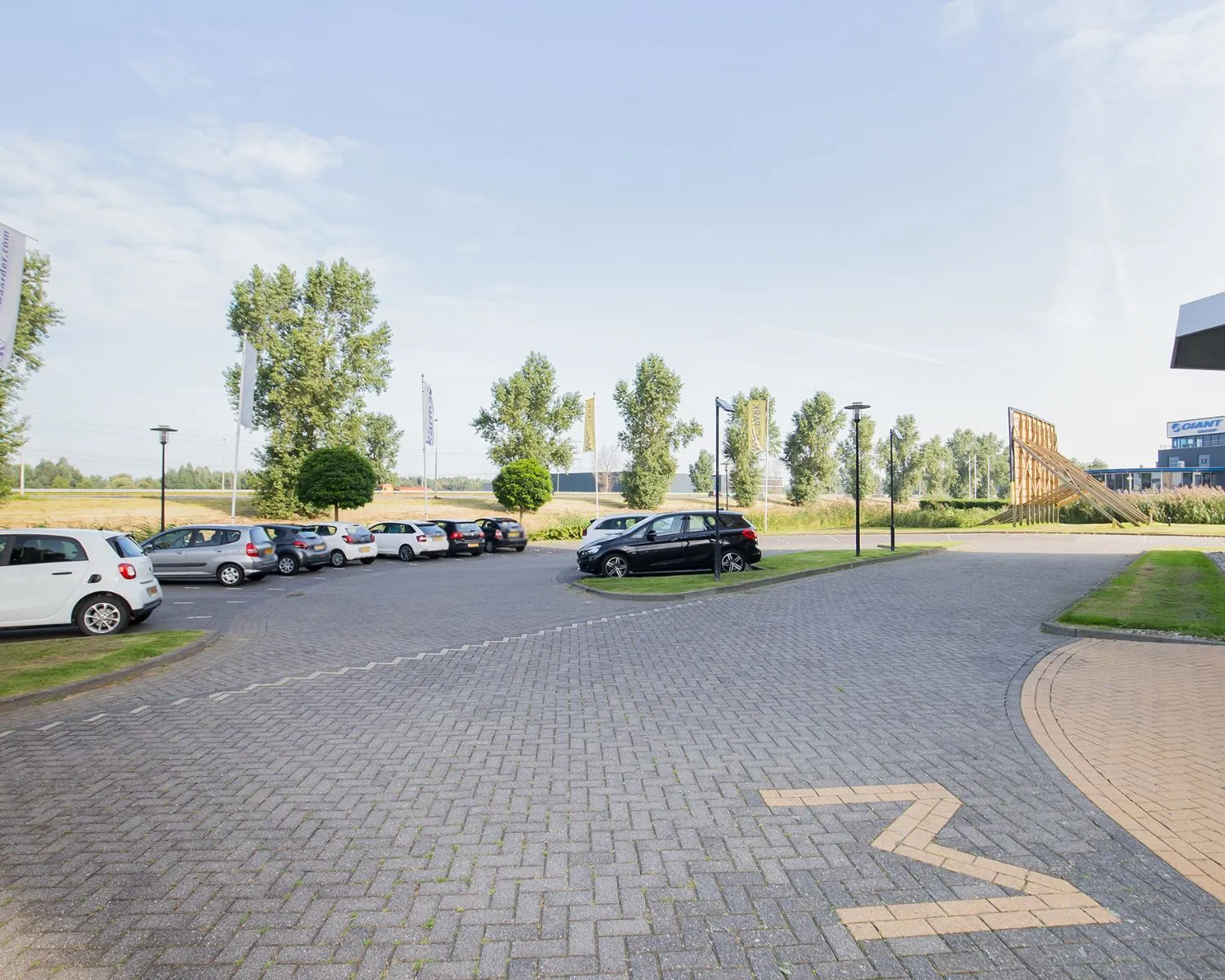 Parkeerterrein bij kantoorruimte aan de Pascallaan 60-78 in Lelystad met geparkeerde auto's en groenstroken.