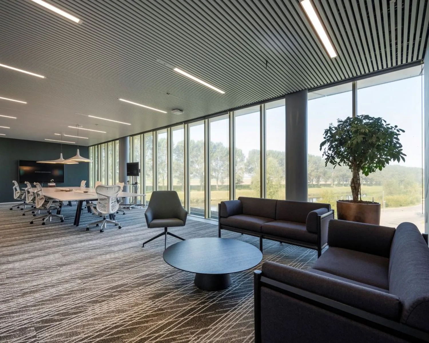 Moderne kantoorruimte met vergadertafel, zitgedeelte en grote ramen aan de Taurusavenue 165 in Hoofddorp.