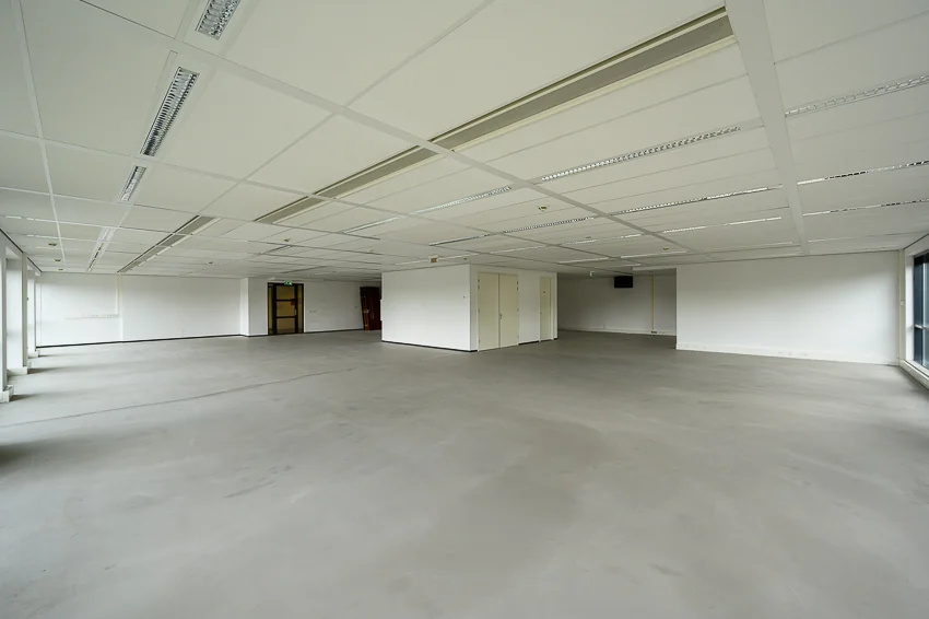 Lege kantoorruimte aan de Maasstadweg met strakke witte wanden, systeemplafond en grote ramen.