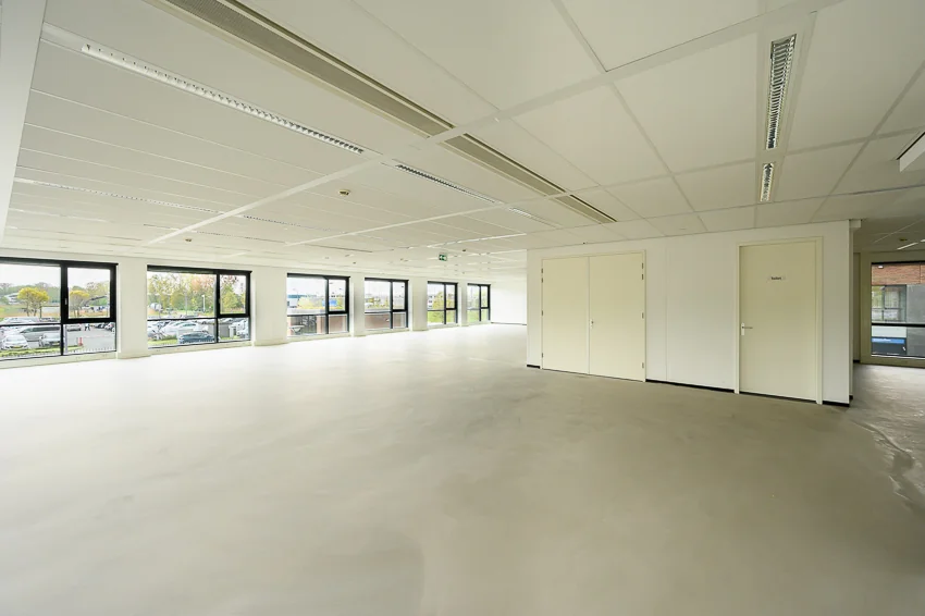 Lichte, lege kantoorruimte aan de Maasstadweg met grote ramen en een systeemplafond.