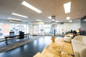 Modern ingerichte kantoor- of winkelruimte aan de Nassaukade met grote ramen, bureaus en zitgedeelte.