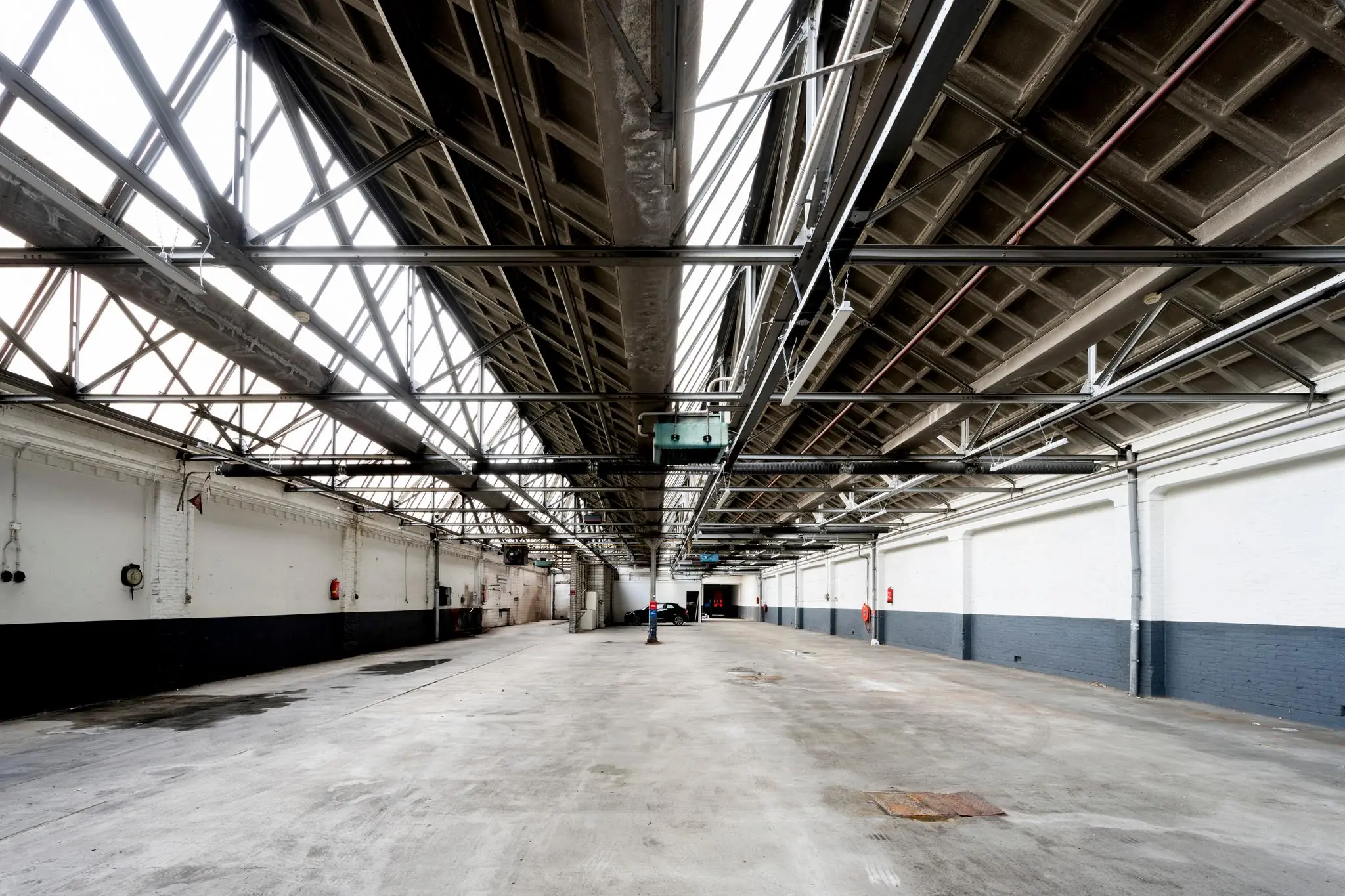 Leeg industrieel pakhuis aan de Nassaukade met betonnen dakconstructie en wit-grijs geschilderde muren.