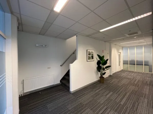 Kantoorhal aan de Utrechtseweg met trap, plant, wandfoto en glazen scheidingswand.