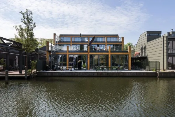 Modern gebouw aan de Nieuwendammerkade met grote glazen gevel aan het water.