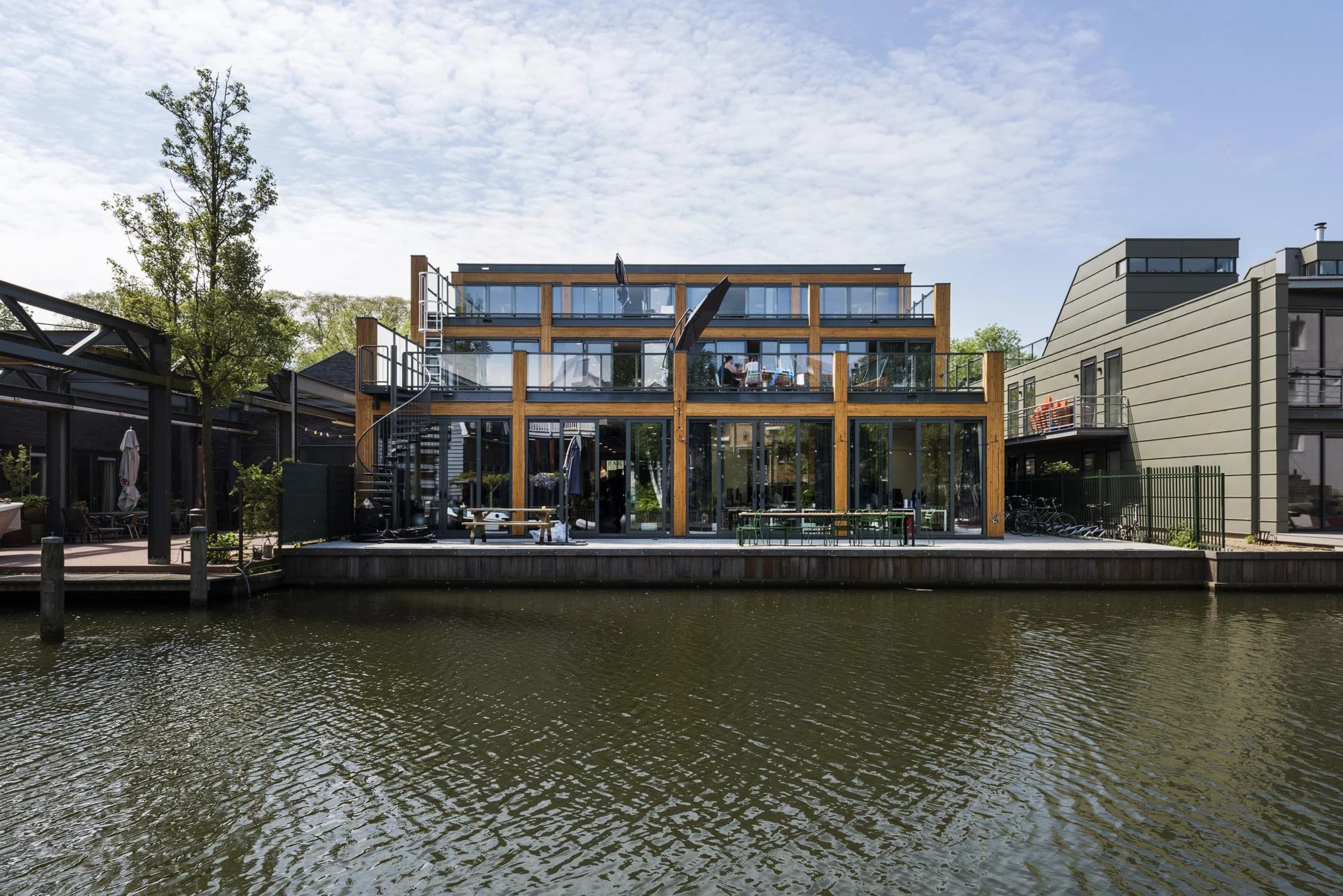 Modern gebouw aan de Nieuwendammerkade met grote glazen gevel aan het water.