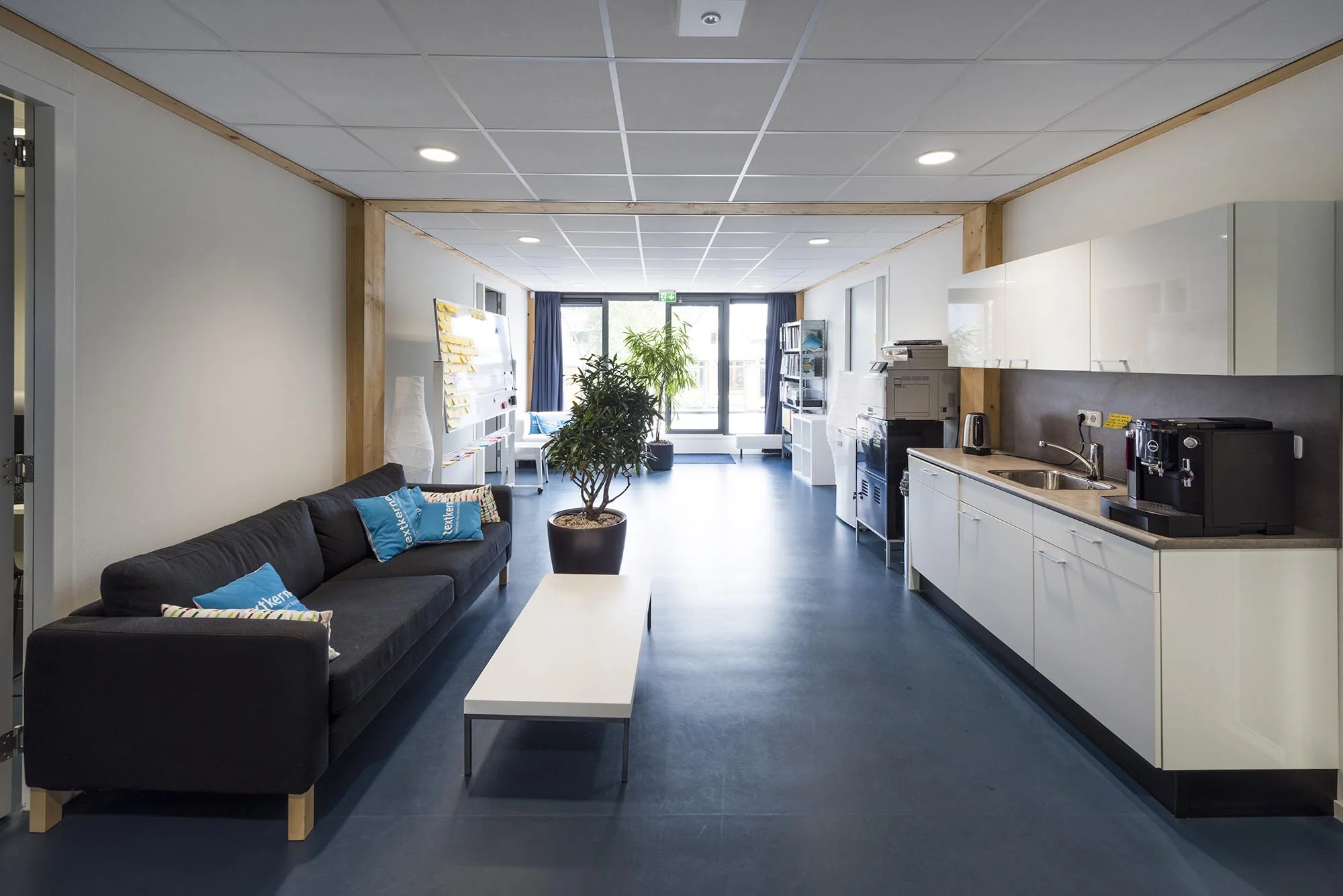 Moderne gemeenschappelijke ruimte aan de Nieuwendammerkade met zithoek, kitchenette en kantoorvoorzieningen.