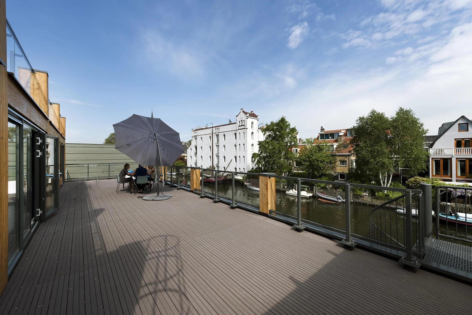 Ruim dakterras aan de Nieuwendammerkade met uitzicht op het water en omliggende woonhuizen.