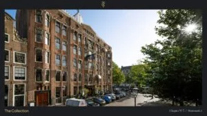 Voorgevel van een historisch kantoorpand aan de Westermarkt 2 in Amsterdam met geparkeerde auto's op de voorgrond en bomen in het zonlicht.