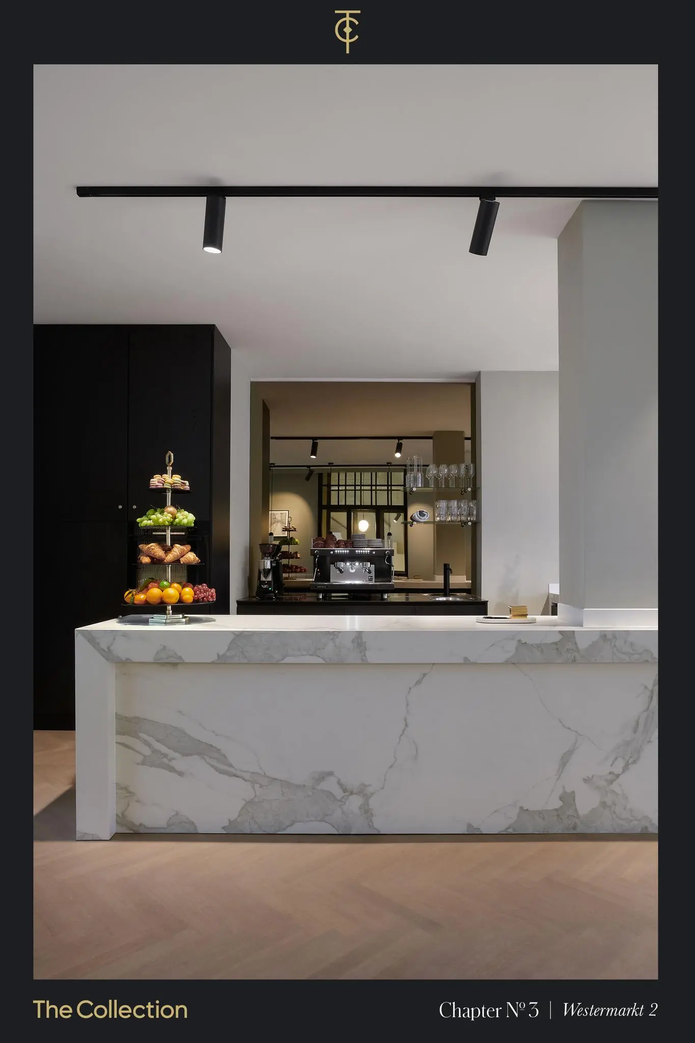 Luxe moderne keuken met een marmeren kookeiland, espressomachine en etagère met fruit en zoetigheden in Westermarkt 2.