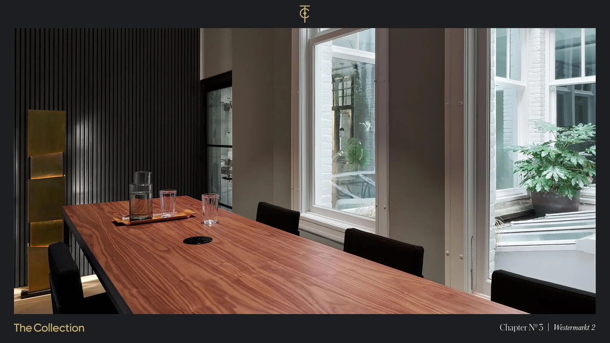 Moderne vergaderruimte met houten tafel, glazen karaffen en uitzicht op een binnentuin aan de Westermarkt 2.