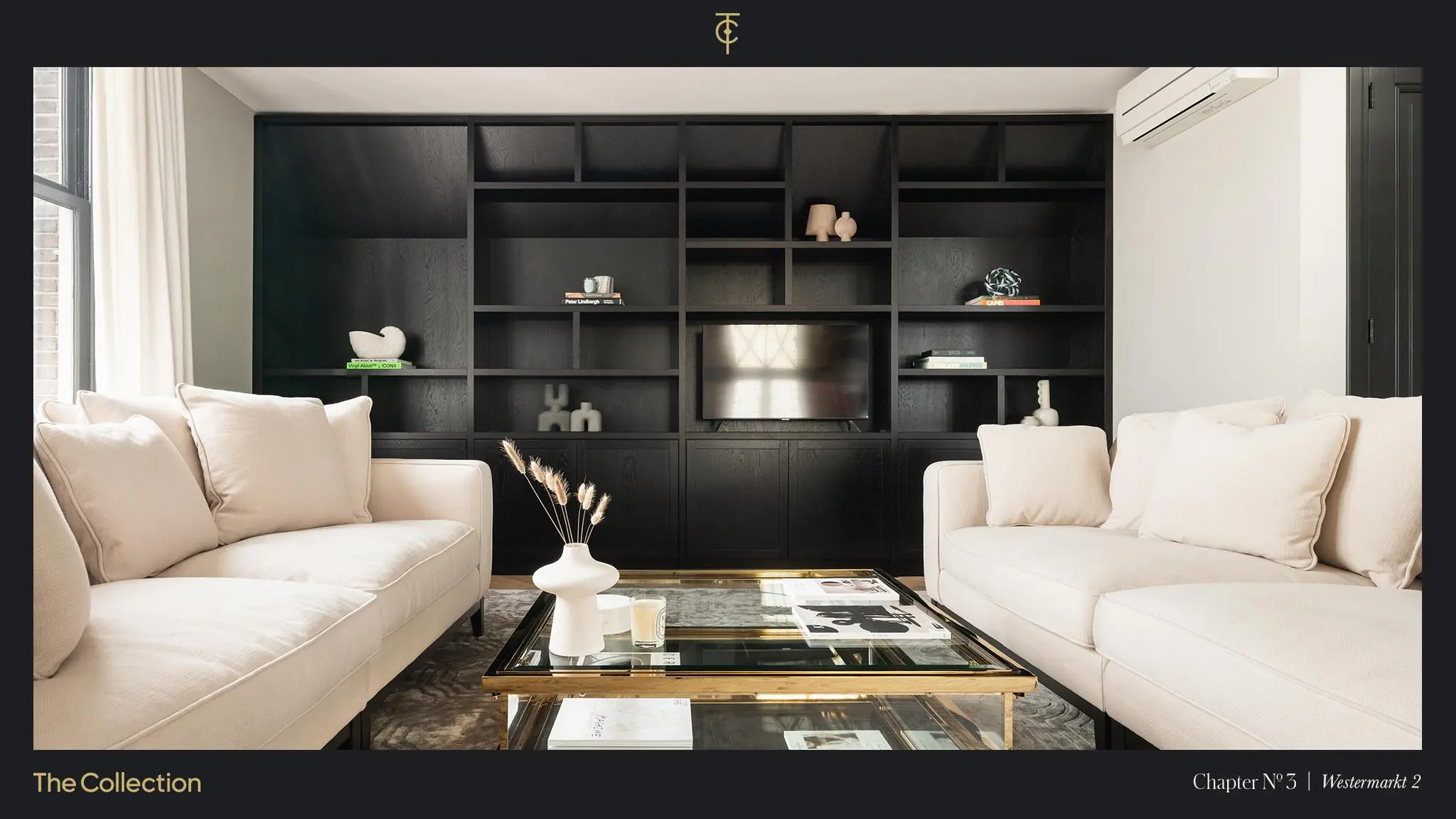 Stijlvol ingerichte woonkamer in Westermarkt 2 met crèmekleurige banken, een glazen salontafel en een zwarte wandkast met tv.