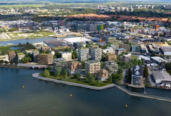 Luchtfoto van nieuwbouwproject aan de Grasweg in Amsterdam-Noord met moderne appartementengebouwen aan het water.