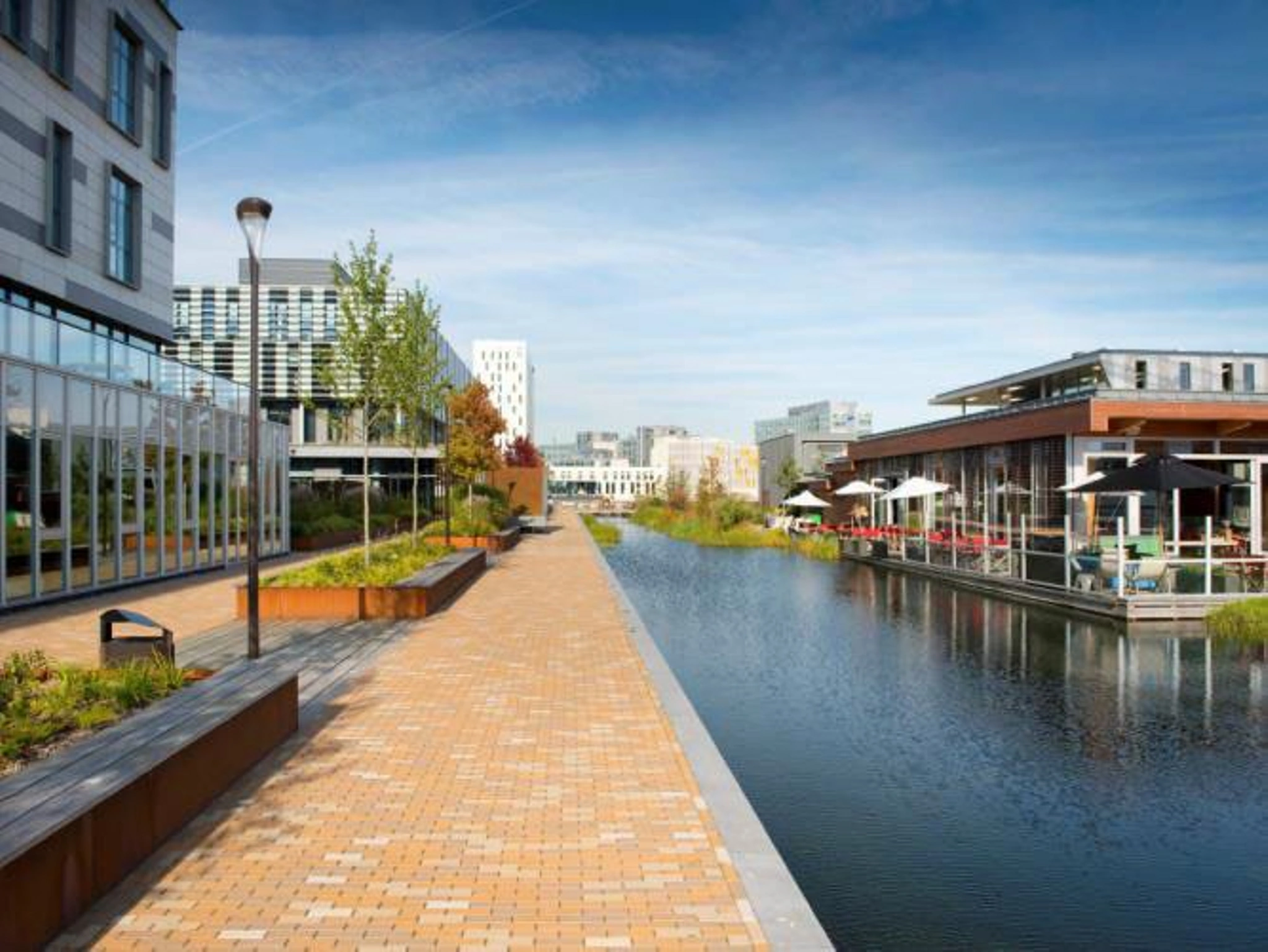 Modern kantoorgebouw Scorpius aan een waterpartij met terras en wandelpad in Amsterdam-Zuidoost.